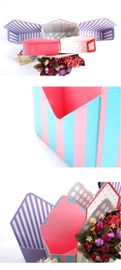 Flat lay of colorful striped and polka dot paper envelope flower boxes and gift packaging