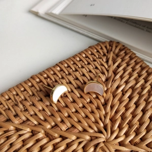 Detail of 925 silver crescent moon earrings with shell inlay on a woven tray