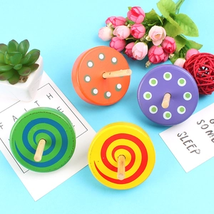 Set of four colorful wooden spinning tops with diverse patterns on a light blue background