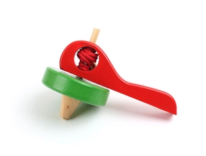Detail view of a traditional wooden spinning top with red handle and green base