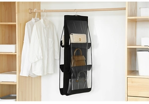 Detail of black hanging handbag organizer with clear PVC windows in a wooden closet
