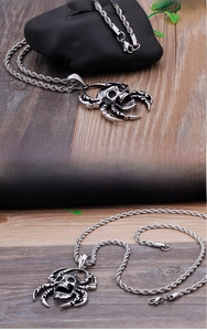 Macro detail of gothic stainless steel skull pendant with vintage silver spider claws