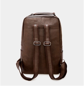 Detail view of the back of a dark brown PU leather backpack with adjustable straps