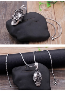 Close-up of gothic skull pendant with detailed engravings on a rustic stone background