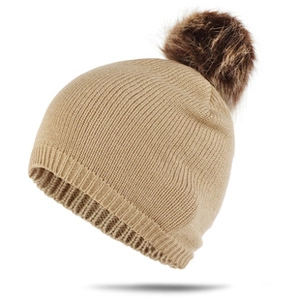 Détail du bonnet de Noël en tricot kaki avec pompon en fausse fourrure et texture côtelée