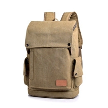 Detail view of khaki canvas backpack with leather trim and magnetic side pockets