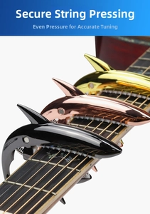 Shark shaped guitar capo detail showing metallic zinc alloy finish and protective silicone pad