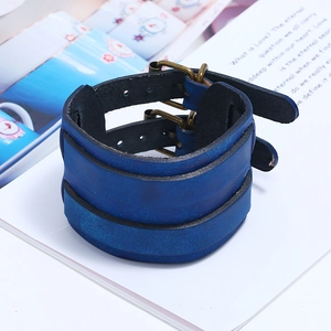 Detail of blue genuine leather punk wristband featuring double bronze buckles and retro texture