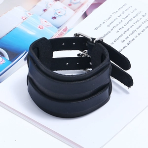 Detail of vintage black leather multi-strap bracelet with metal buckles on white surface