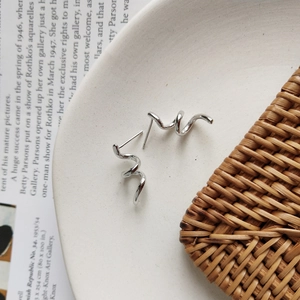 Elegant 925 sterling silver spiral earrings displayed on a white ceramic plate