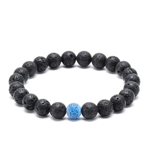 Vue macro de perles de lave noire 8mm et agate bleue craquelée sur bracelet perlé