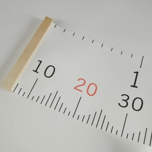 Detail of wooden hanging rod and precise scale marks on cartoon canvas height chart