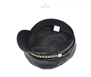 Detail view of black PU leather baker boy hat with gold chain and interior size label