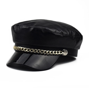 Detail of black PU leather newsboy hat featuring decorative gold chain and glossy brim