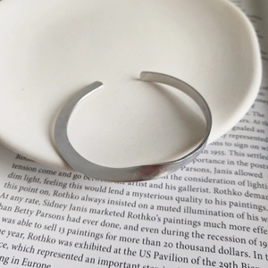 Dettaglio del bracciale ritorto in argento opaco con trama spazzolata su ceramica