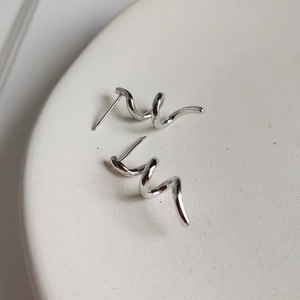 S925 sterling silver spiral earrings with polished finish on a ceramic tray