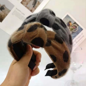 Close-up of plush leopard print headbands in brown and grey with soft fuzzy texture