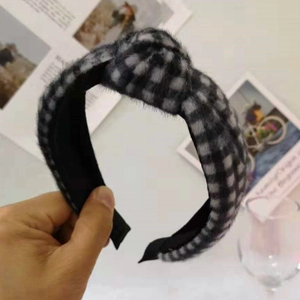 Detail showing plush black and white checkerboard headband with top knot and soft texture