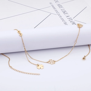 Elegant gold anklet featuring clover, heart and infinity charms on a delicate metal chain