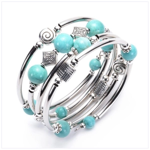 Detailed view of silver multi-layer wrap bracelet with turquoise beads and engraved charms