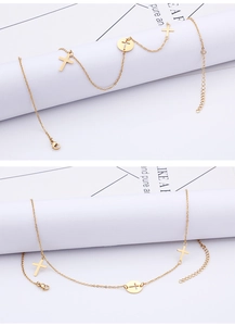 Detail view of gold cross pendant anklet with delicate chain and adjustable lobster clasp