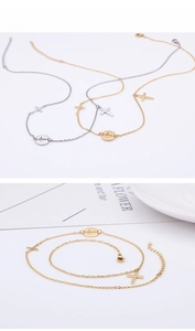 Detailed view of silver and gold cross pendant necklaces on a minimalist white tray