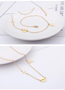 Detail of gold cross pendant necklace with round cutout charm and fine O-chain link