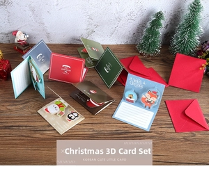 Detail view of 3D Christmas pop-up cards with Santa and animals on a wooden desk