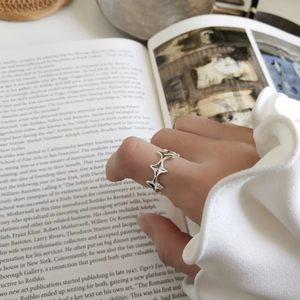 Close-up of a 925 sterling silver vintage irregular star ring styled on an open book