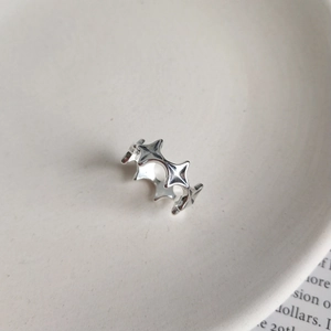 Detail of minimalist 925 sterling silver ring with interconnected four-pointed star patterns