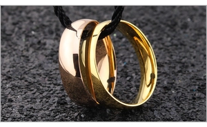 Detailed close-up of rose gold and gold stainless steel rings hanging on a black cord
