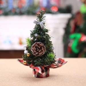 Close-up of 20cm mini Christmas tree with pine cones, bows and festive red plaid base