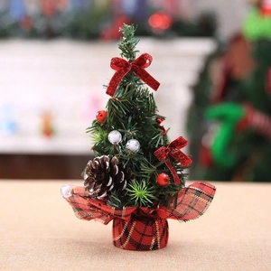 Close-up of a 20cm mini Christmas tree with red bows, pine cones and plaid base