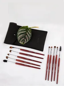 Detailed set of 10 professional makeup brushes with brown wooden handles and storage pouch