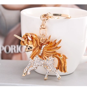 Detailed macro view of golden unicorn keychain with sparkling white rhinestones
