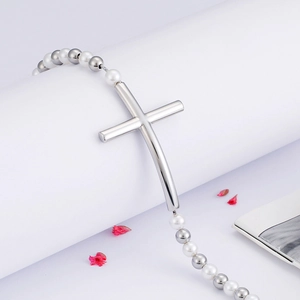 Titanium steel beaded bracelet with silver cross and pearls on minimalist white base