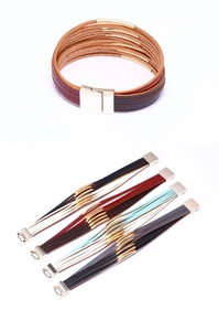 Detail view of multi-layer leather bracelets with gold metal tubes and magnetic clasps
