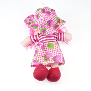 Detail of pink strawberry themed cloth doll showing fabric texture and hanging loop