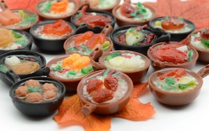 Macro shot of realistic mini PVC food charms with noodles and eggs in frying pans