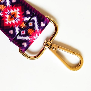 Close-up of bohemian style purple geometric woven strap with golden metal lobster clasp