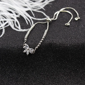 Detailed close-up of a silver butterfly charm bracelet featuring sparkling zircon stones