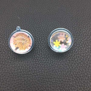 Detailed view of DIY resin sphere pendants with dried flowers and colorful star sequins