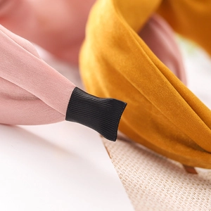 Detailed macro view of pink and yellow velvet headbands with secure black fabric ends