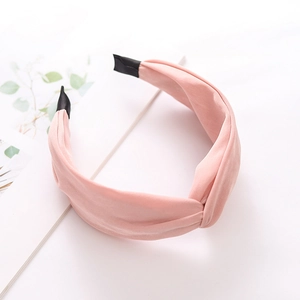 Detail of pink wide knot headband with silky fabric texture on a minimalist background