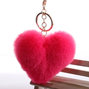 Fuchsia plush heart keychain with gold ring on a miniature bench background