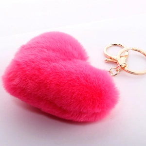 Close-up of fluffy rose pink plush heart keychain with gold-tone metal clasp and ring