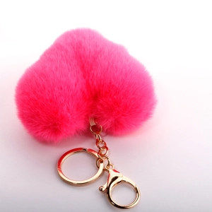 Macro shot of fluffy pink heart-shaped faux fur keychain with gold lobster clasp