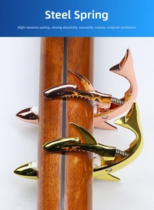 Detail of rose gold shark shaped guitar capo with high tension steel spring on neck