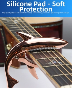 Detailed close-up of a rose gold shark guitar capo with white protective silicone pads