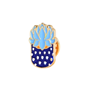 Creative blue lotus enamel pin with golden metal base and white polka dots on white background